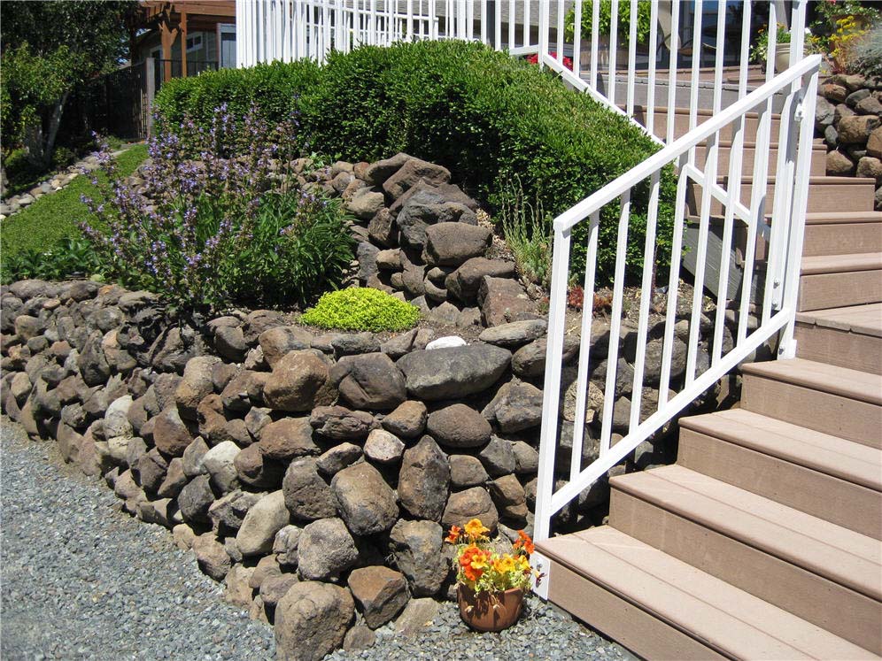 Stacked Rock Wall and White Metal Fence